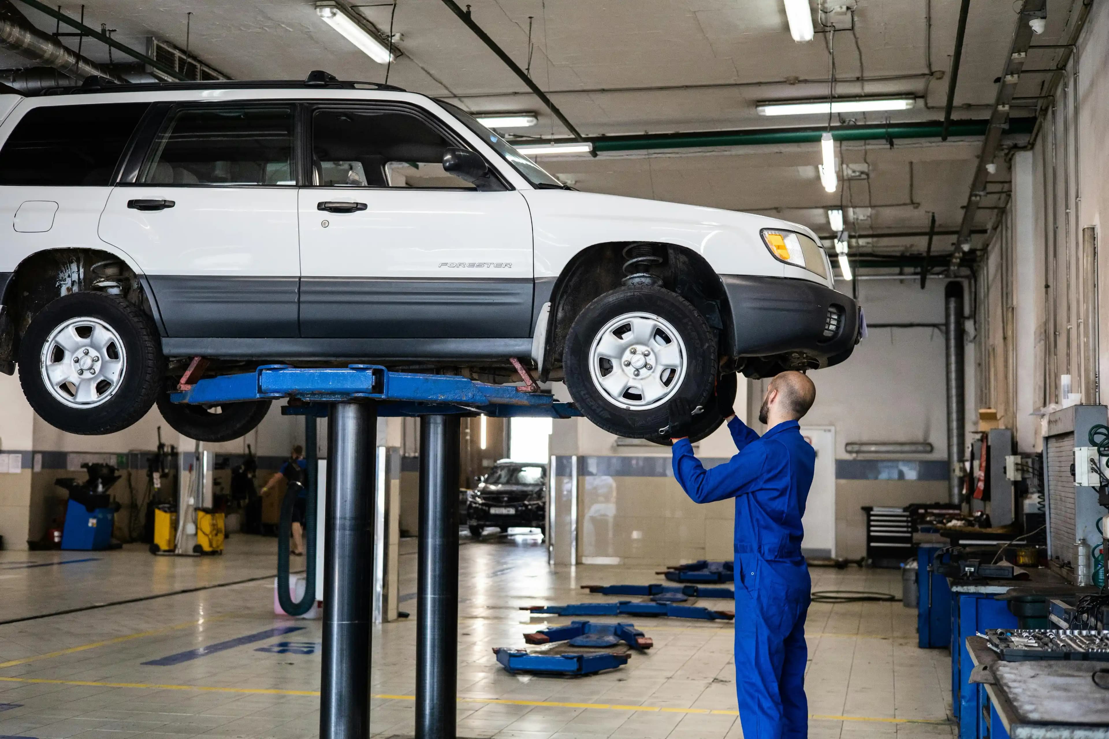 Un technicien entretient un véhicule de flotte dans un garage partenaire
